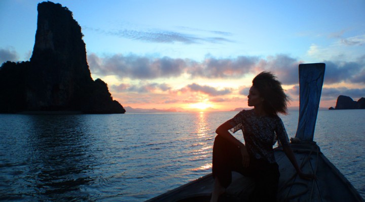 The Global Girl Travels: Ndoema takes in the sunrise on a traditional thai long boat in the Andaman Sea.