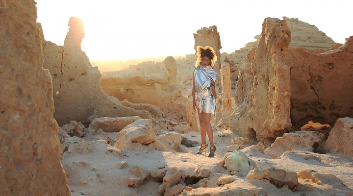 The Global Girl Fashion Editorials: Ndoema goes futuristic in a silver metallic dress against the ancient ruins of Shali Ghadi, a spectacular 13th-century fortress at Siwa Oasis, Egypt.